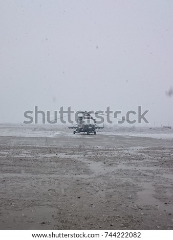 Helicopter on the airfield and snow