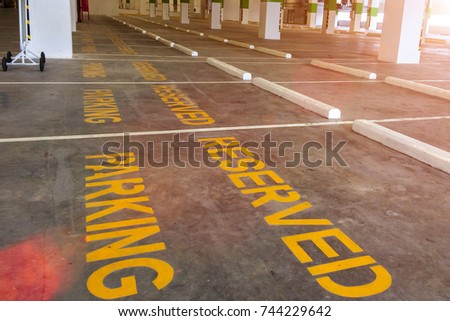 Perspective View of Empty Reserved Parking Space with Yellow Reserved Parking Sign on the Floor with Sun Light Shade used as Template