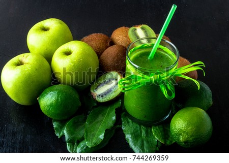 Green smoothie near ingredients for it on black wooden background. Apple, lime, spinach, kiwi. Detox. Healthy drink. Clear food.