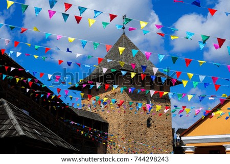 Party colorful flags and Castle on back against blue sky background. Holidays flags decoration image.