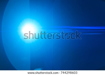 The blue spot of light on the black background. anamorphic lens flare