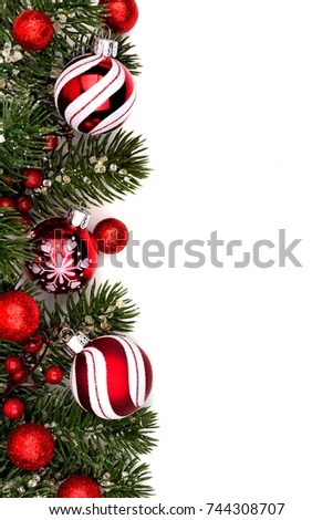 Christmas border of red and white baubles with branches isolated on a white background