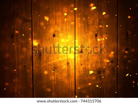 Background of wooden boards with snow and glitter bokeh effect.