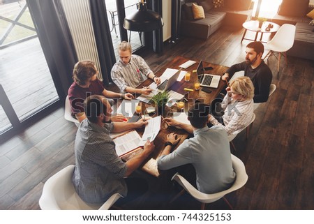 Teamwork on new business project in loft space. Group coworkers making great business decisions. Creative managers discussion work concept modern office Royalty-Free Stock Photo #744325153