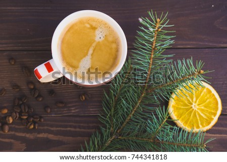 Cup of coffee and christmas fir branch on wooden table. Top view