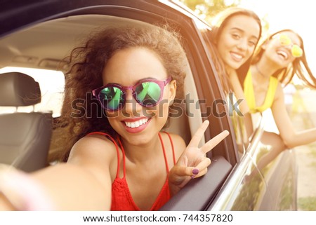 Beautiful young women looking out of car window