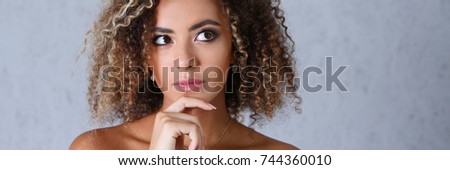 Beautiful black woman portrait. Looks upwards to the right and the picture of the thought process beauty fashion style curly hair with white locks eye view of the camera