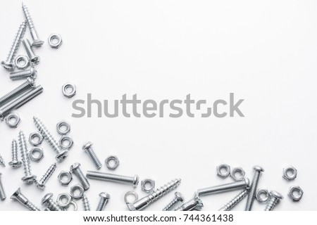 Collection Of Iron Screws, Nuts and Lockwashers At The Left und Bottom Border Of A Whitebox Royalty-Free Stock Photo #744361438