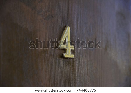Old vintage aged scratched number letter 4 four on the old door