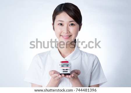 Female nurse holding toy ambulance.