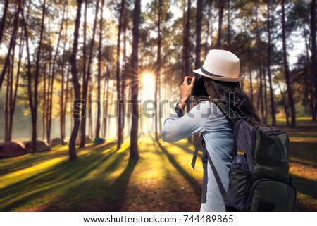 traveller woman photographer shooting with slr camera in sunrise with nature beautiful landscape in background. Photographer taking travel nature photography.