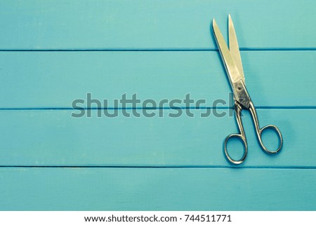 Scissors for a cloth on a blue wooden background.