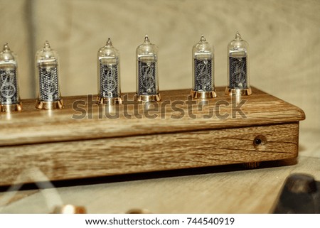 Old tube clock in wooden case on the background of wooden boards