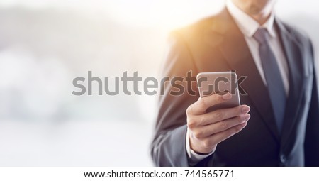Close up of a business man using mobile smart phone, background for copy.