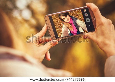 young beautiful happy woman doing autumn selfie on smartphone for social network