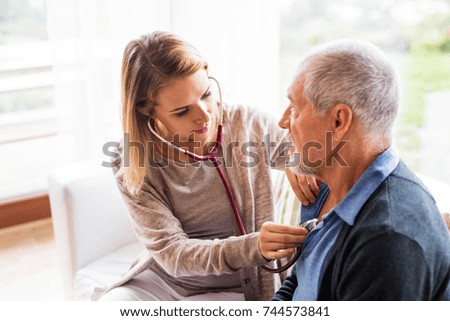 Health visitor and a senior man during home visit. Royalty-Free Stock Photo #744573841