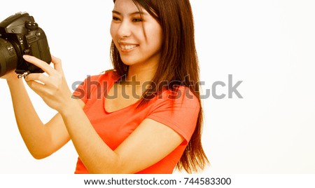 Young asian female photographer happy looking at camera pictures. Isolated on white.