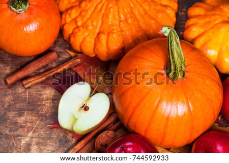 Harvest or Thanksgiving background with pumpkins, apples and fallen leaves on wooden background  with copyspace. Halloween, Thanksgiving day or seasonal autumnal concept.
