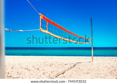 Volleyball net and empty beach. Sea Beach and Soft wave of blue ocean.  Summer day and sand  background.
