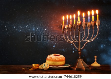 image of jewish holiday Hanukkah background with menorah (traditional candelabra) and burning candles Royalty-Free Stock Photo #744618259