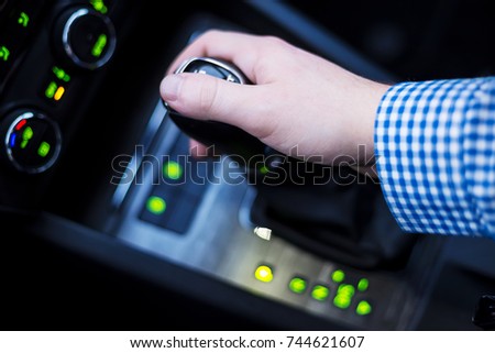 Hand holding shift lever of automatic transmission Royalty-Free Stock Photo #744621607