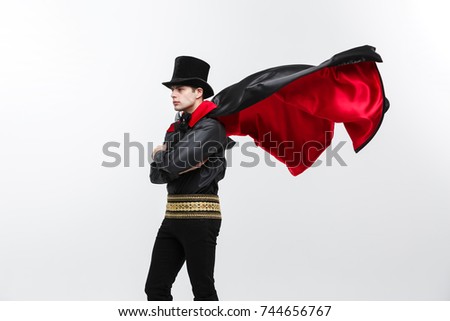 Vampire Halloween Concept - Portrait of handsome caucasian Vampire halloween costume fluttering his red, black cloak. 