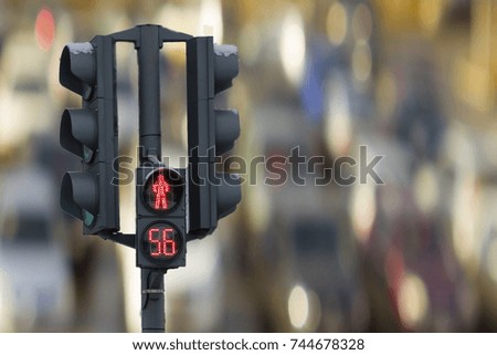 pedestrian traffic light with a red timer shows on the background of the car.