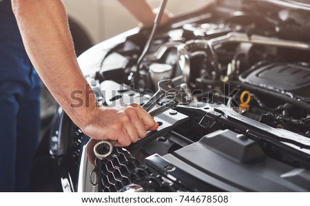 Picture showing muscular car service worker repairing vehicle. Royalty-Free Stock Photo #744678508