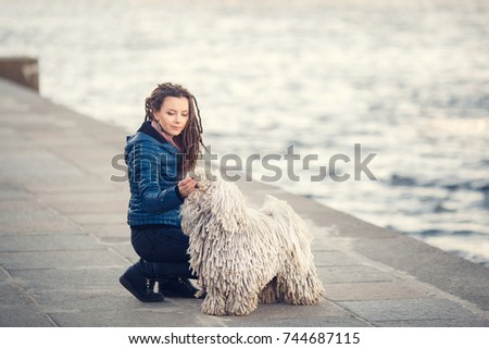 Young woman with puli dog sitting at the street. City. Lifestyle.