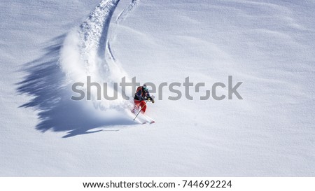 Free ride skier skiing down through fresh powder Royalty-Free Stock Photo #744692224