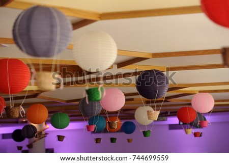 Beautiful colored paper lanterns hanging on the ceiling as air balloons