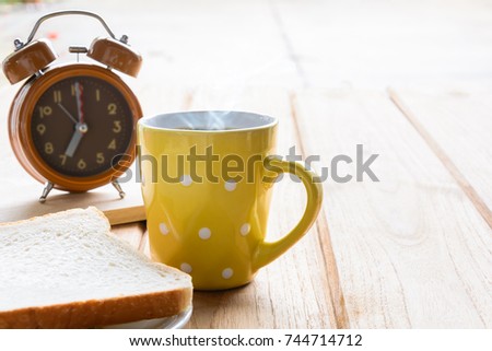 Good morning black coffee cup and bread on a wooden table in the sunrise background. breakfast and wake up