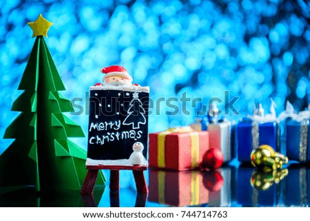 santa claus and gifts and toys on glass table and bokeh blue light background with Christmas holidays and happy smile kids.selective focus