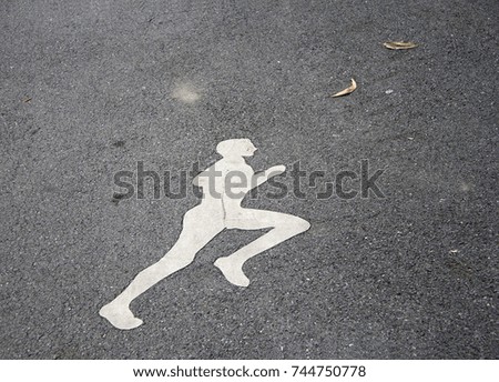 The white jogging man painting on the jogging lane. run at a steady gentle pace, especially on a regular basis as a form of physical exercise.