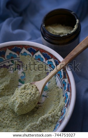 Ubtan preparation. Spoon poured ubtan in a jar.