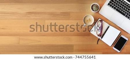 Top view of office desk on wooden background 