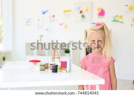 Little girl at painting lesson in classroom