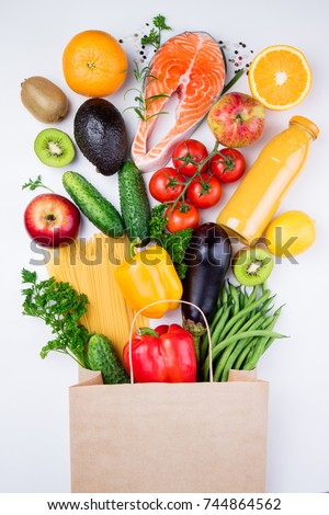 Healthy food background. Healthy food in full paper bag of different products fish, vegetables and fruits on white background. Top view Royalty-Free Stock Photo #744864562
