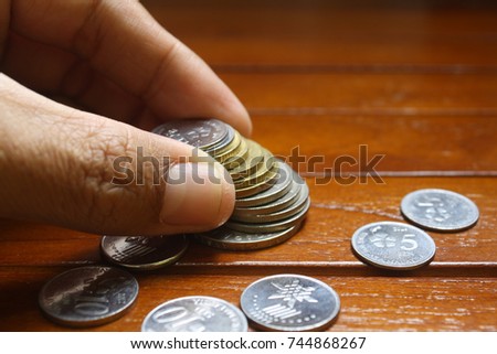 Photo for finger pick a coins on wooden tables with natural light.