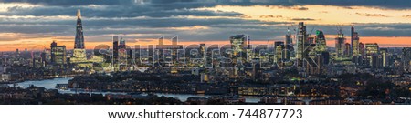 Panorama of the new skyline of London, United Kingdom, after sunset, city lights along the Thames river