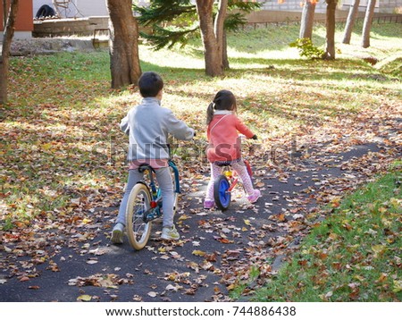 An infant boy and girl practicing bicycle