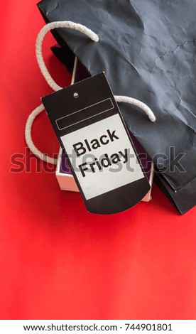 Black Friday tag and black shopping bag on red background