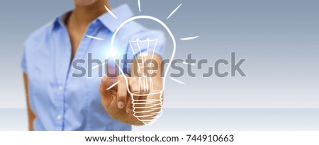 Businesswoman on blurred background touching a sketch lightbulb
