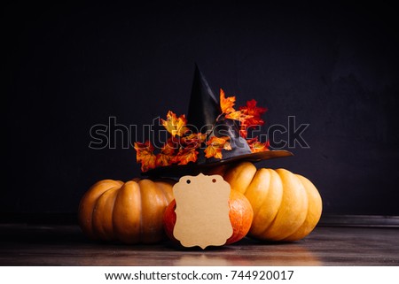 a few small pumpkins decorated with a black hat
