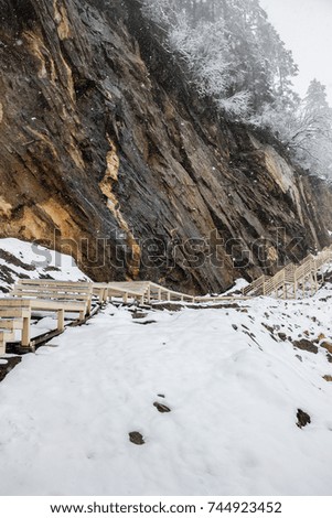 wooden footpath at snowy mountain cliff in winter  