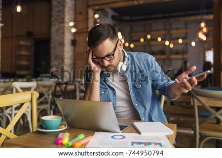 Freelancer having problems while working at the coffee house Royalty-Free Stock Photo #744950794