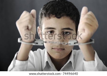 Kid with handcuffs on hands Royalty-Free Stock Photo #74496640
