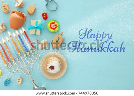 Top view image of jewish holiday Hanukkah background with traditional spinnig top, menorah (traditional candelabra) and burning candles