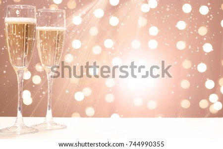 Two glasses of champagne on the background of festive garlands, copy space for your text on the right.