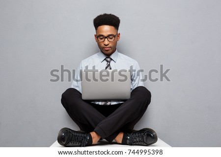 Business Concept - Happy handsome professional african american businessman enjoy playing on labtop.